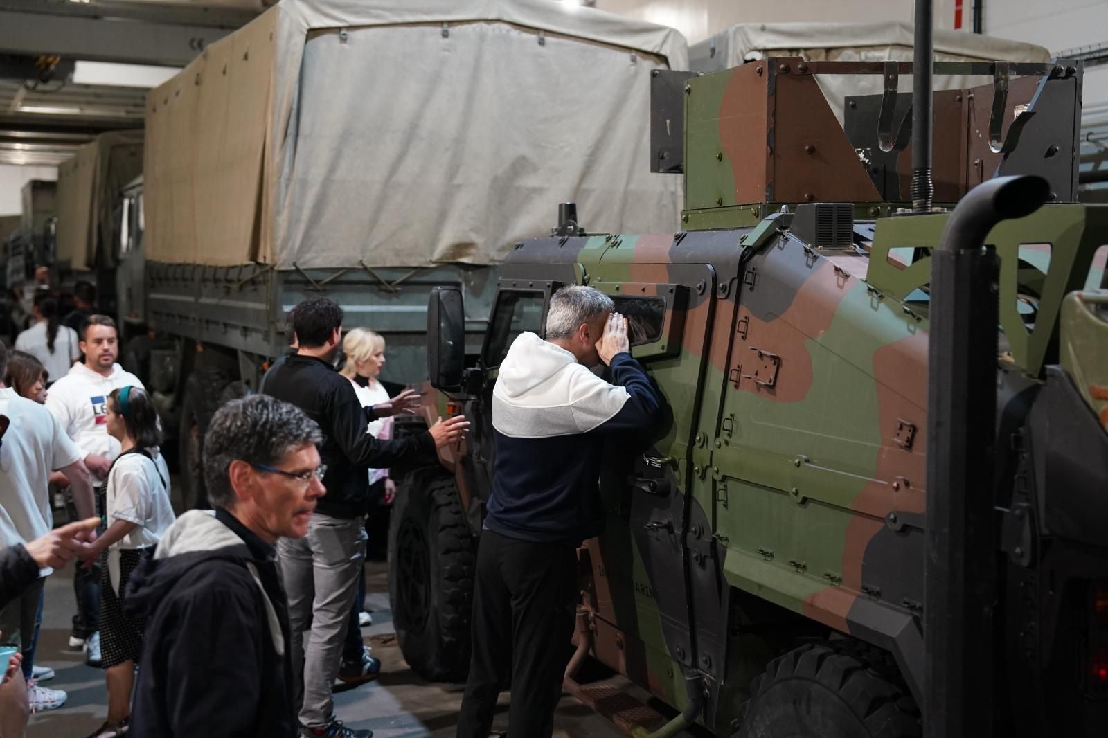 Visitantes observan un vehículo militar en el portaviones