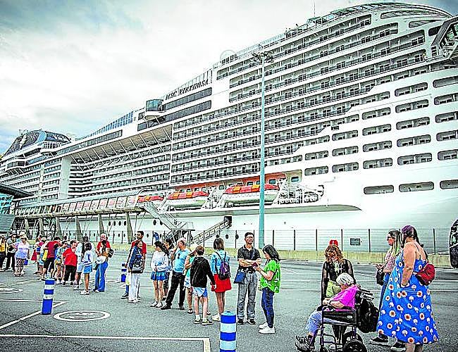 Pasajeros hacen cola para tomar un autobús.