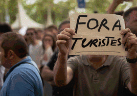 Los manifestantes de Barcelona en plena protesta ante los turistas comiendo en las terrazas.