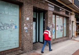 Una persona ajena a la información camina junto a la lonja okupada donde se originó la pelea multitudinaria.