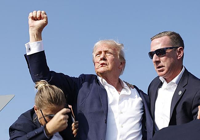 Trump, protegido por los integrantes del servicio secreto al bajar del escenario.