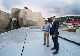 Juan Ignacio Vidarte y Rogelio Diez visitan una de las azoteas donde se han instalado los paneles de color azul.