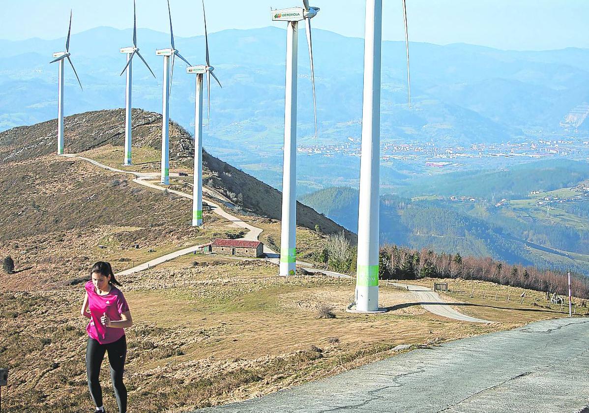 Una joven hace deporte junto al parque eólico del monte Oiz.