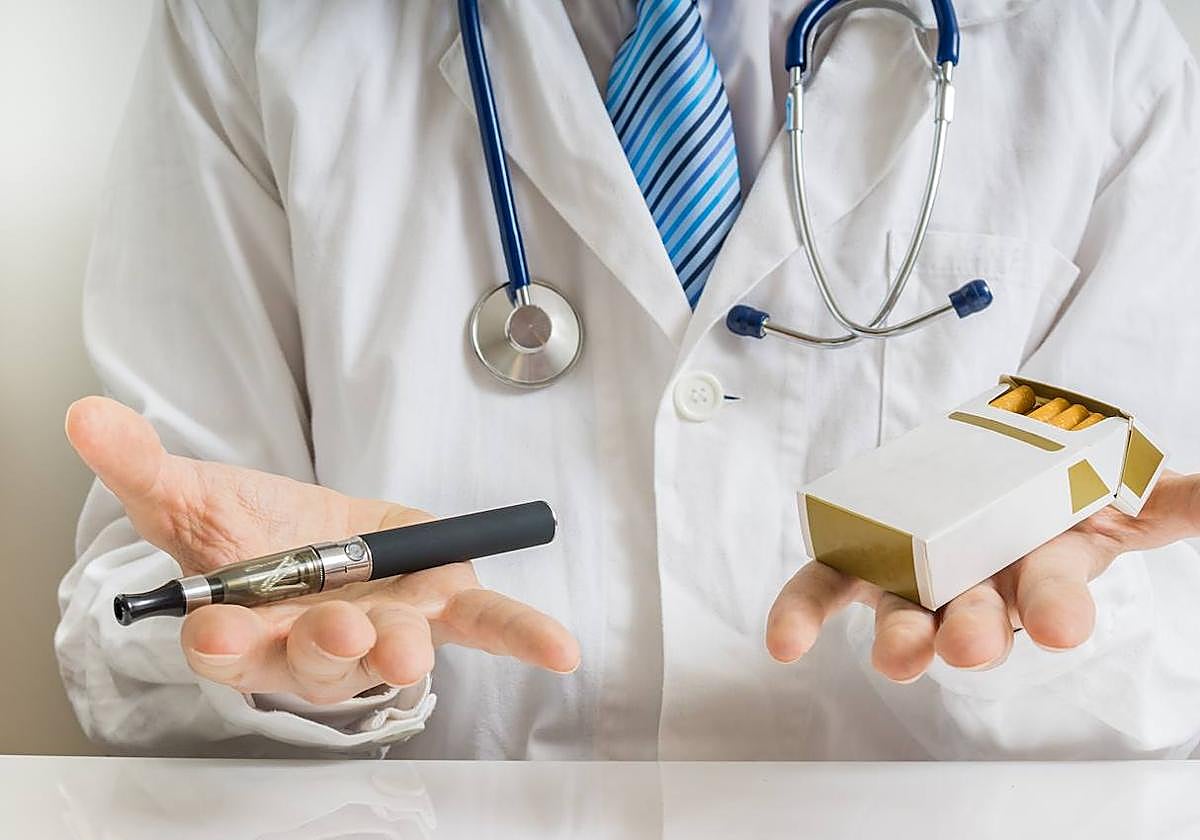 Un médico sostiene en la mano un vapeador y tabaco, mientras habla sobre el nocivo impacto que ambos productos tienen en la salud humana.