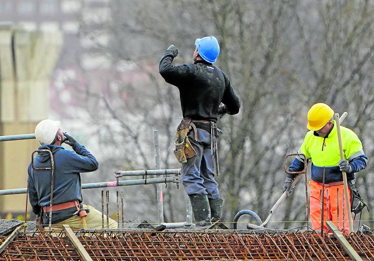 Empleados de la construcción trabajan en la obra de un edificio en una localidad vizcaína.