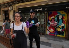 Bea Aparicio y Charlee Mito son los encargados de decorar las persianas del bar Sorginak y la academia de peluquería.