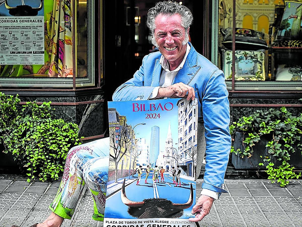 Goitia posa con el cartel taurino delante de su tienda.