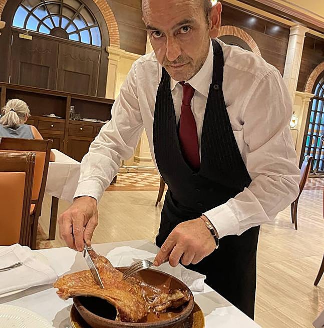 El maître Sergio Martínez Caballero emplata un cuarto del notable lechazo.