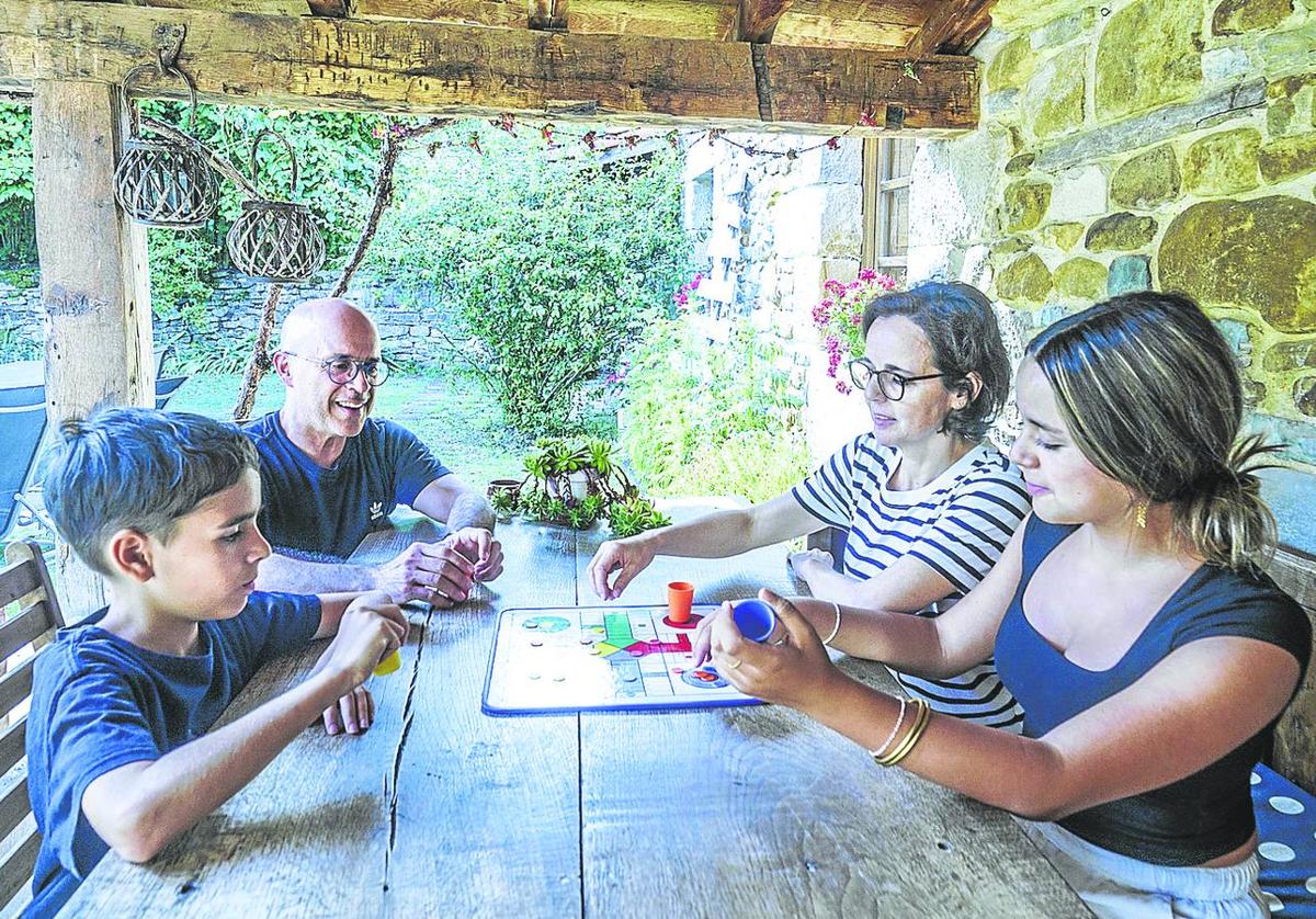 La familia Carbonell-Carrión juega en el porche de la casa Guikuri al parchis.