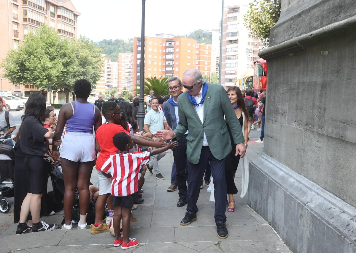 Imagen secundaria 1 - Arriba, los capitanes De Marcos y Oguiza durante la ofrenda a la Virgen de Begoña. A la izquierda, el 'Chopo' Iribar saluda a pequeños aficionados del Athletic. A la derecha, el presidente Jon Uriarte durante su discurso junto al cura José Luis Atxotegi.