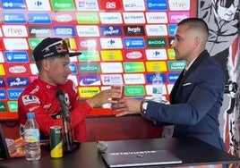 Cristian Ventura sirve un vaso de agua a Roglic, ganador de la cuarta etapa de la Vuelta.