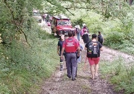 Los pasajeros caminan por la pista forestal en compañía de agentes de la Policía Foral de Navarra.