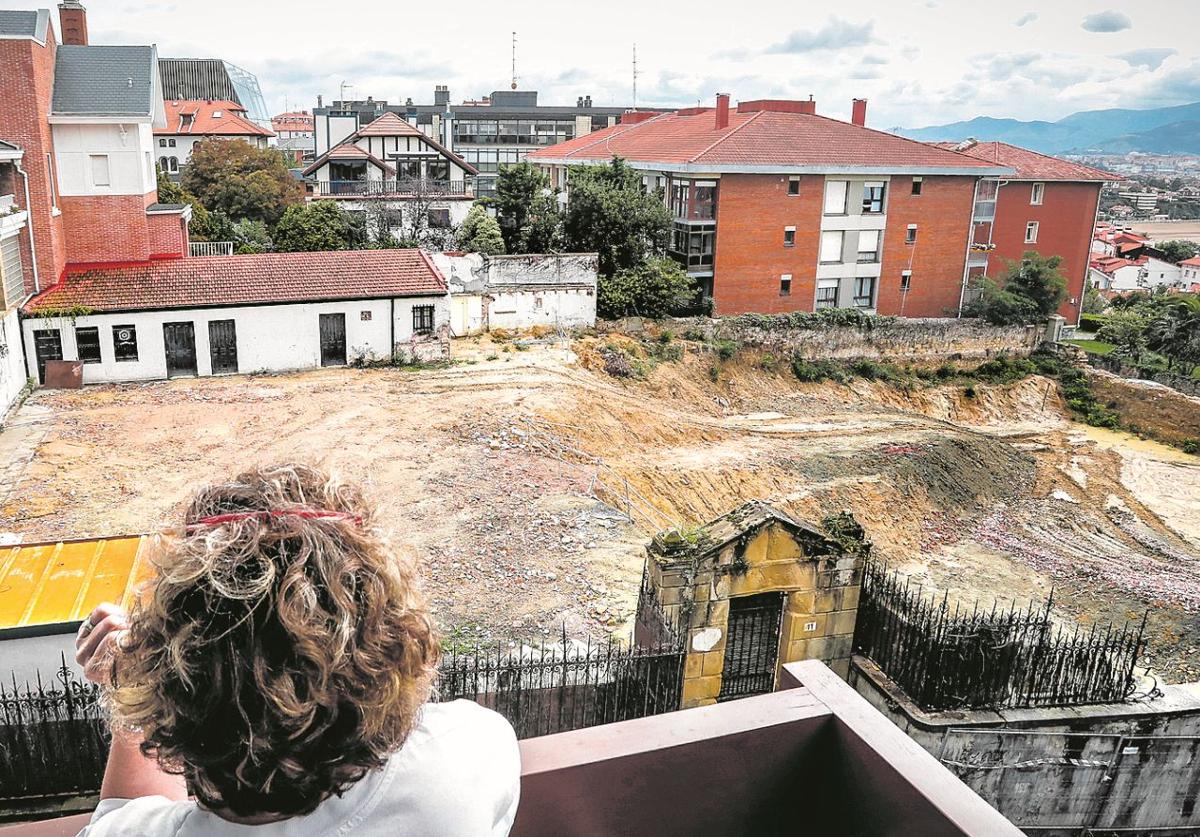 Una vecina contempla cómo ha quedado el solar tras el derribo del palacete de estilo neoclásico que ha indignado a los residentes.