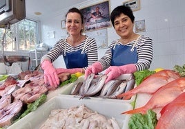 Miren Aintzane Gorostiza (a la izquierda), con la foto de su aita al fondo, posa en su pescadería de Gernika, junto a su compañera Ane Fradua.