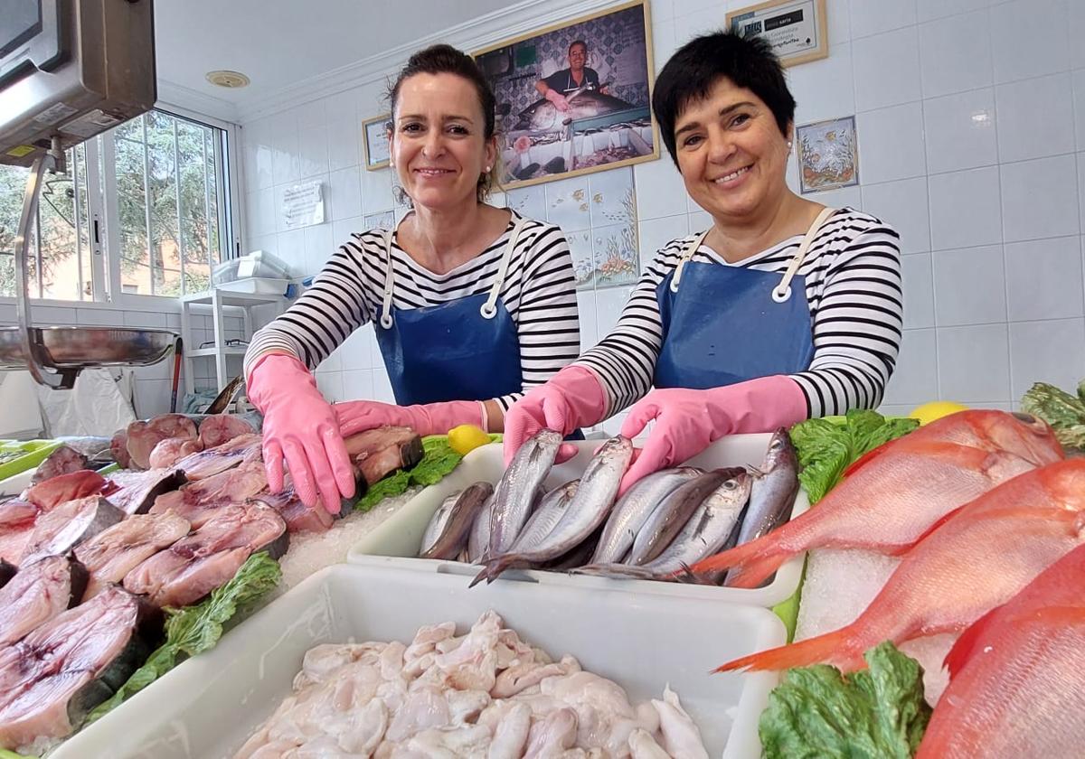 Miren Aintzane Gorostiza (a la izquierda), con la foto de su aita al fondo, posa en su pescadería de Gernika, junto a su compañera Ane Fradua.