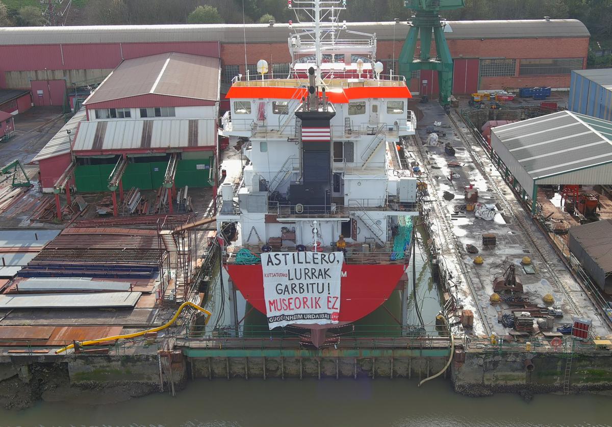 Pancarta de protesta contra el proyecto de expansión del Guggenheim en Urdaibai colocada en la popa de un barco en construcción en Astilleros de Murueta.