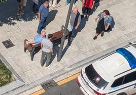 La víctima acompañada de algunos traseúntes esperando a la llegada de la ambulancia.