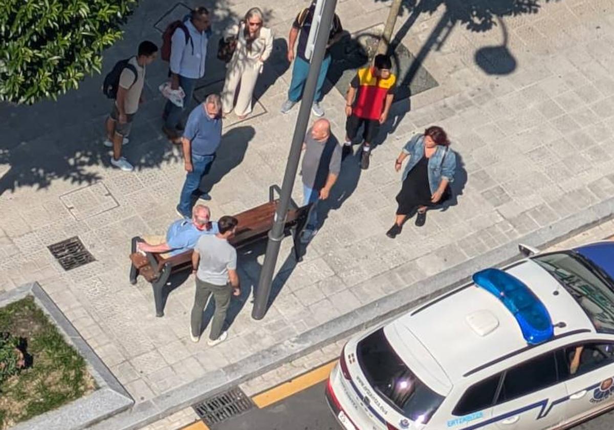 La víctima acompañada de algunos traseúntes esperando a la llegada de la ambulancia.