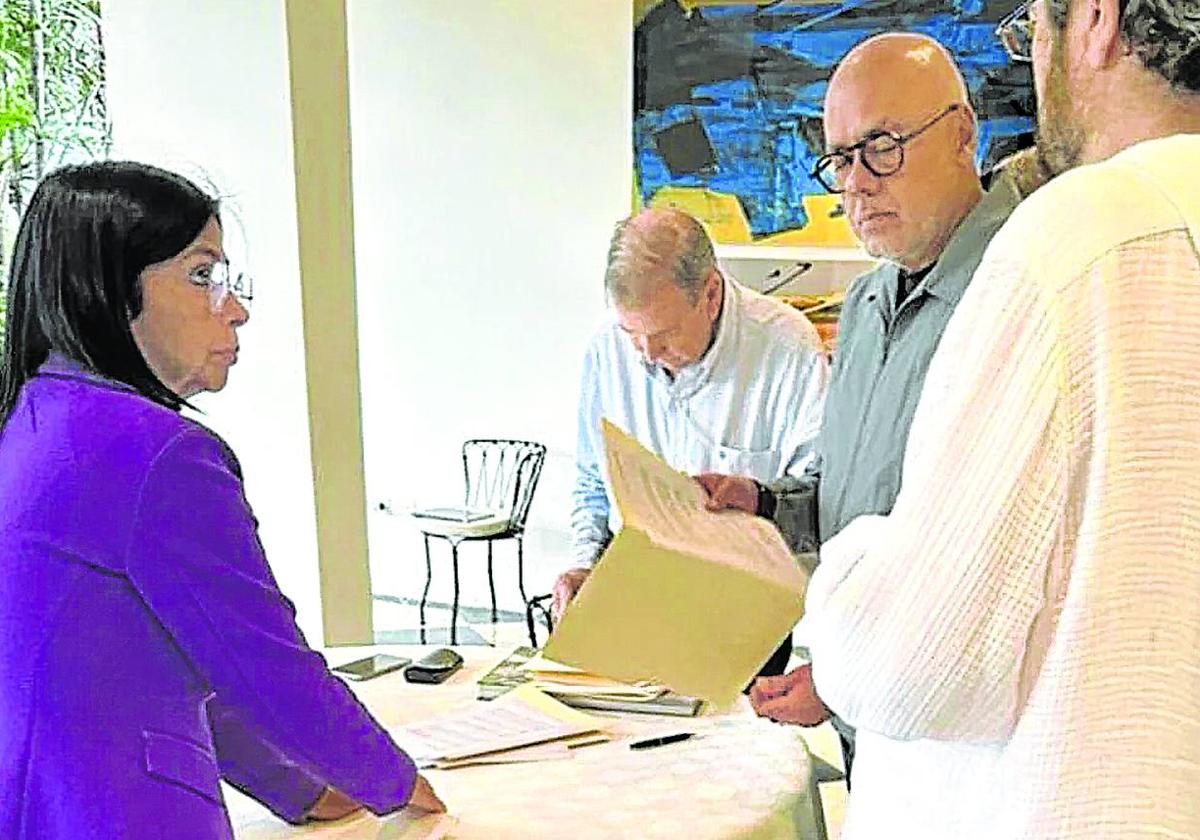 Momento en el que Edmundo González firma el documento en la Embajada de España en presencia de Delcy y Jorge Rodríguez.