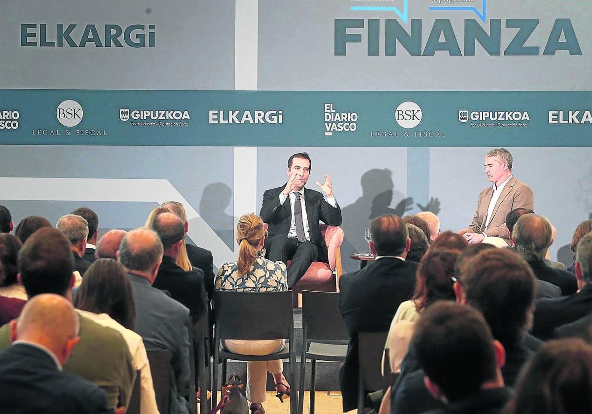 El ministro de Economía, Comercio y Empresa, Carlos Cuerpo, y el moderador Urko Odriozola, durante el Foro Finanza, ayer en Miramón, promovido por Elkargi.