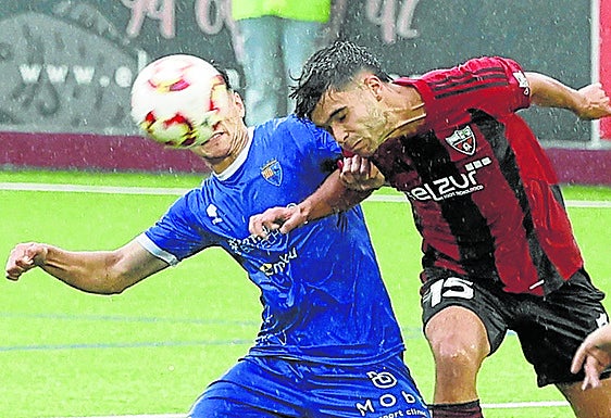 Un jugador del Arenas despeja un balón de cabeza.