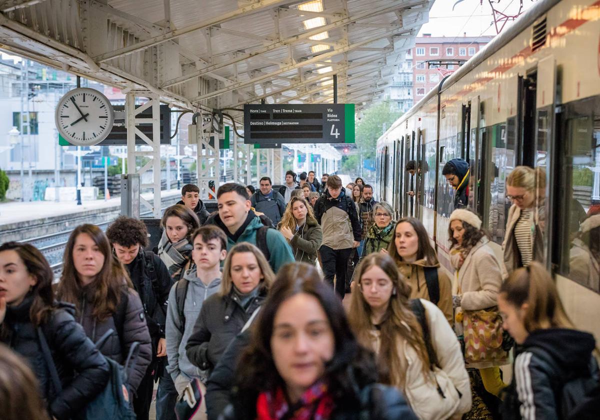 Cientos de personas descienden del cercanías a su llegada a la estación de la calle Dato.