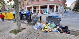 La basura se acumula en los contendores frente a la salida del metro de Sopela.