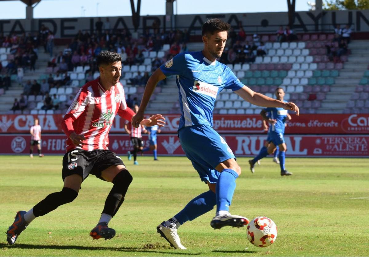 Kortazar protege la pelota ante la presión de un rival.