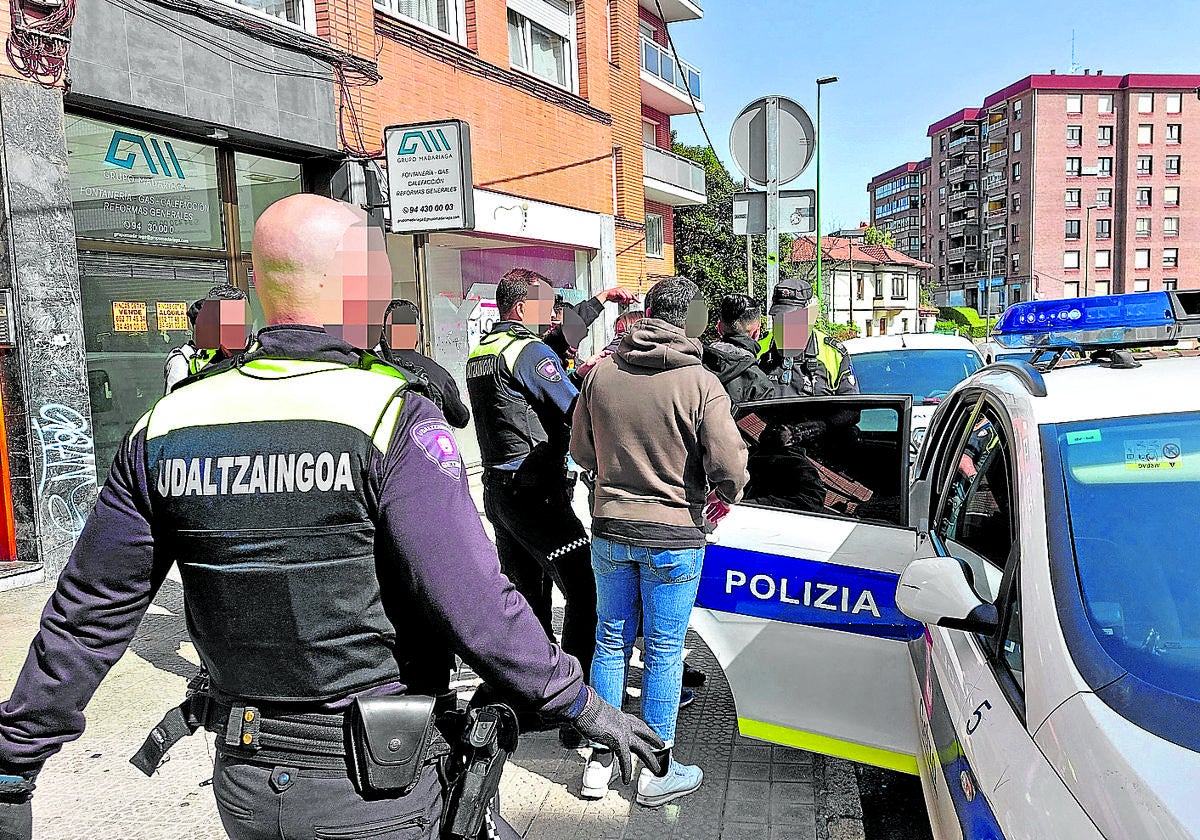 Agentes de la Policía Local de Getxo registran a varias personas que estaban ocupando una casa en el centro de Algorta.