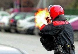 Imagen de archivo de un agente de la Ertzaintza disparando en 2006 una pelota de goma con una de las viejas escopetas 'benelli'.