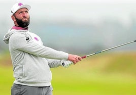 Rahm mira con rostro serio el rumbo de una bola tras jugar un hierro en el Old Course de St. Andrews, Escocia.