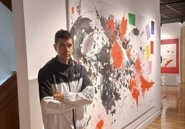 El artista durangués posa con uno de sus cuadros