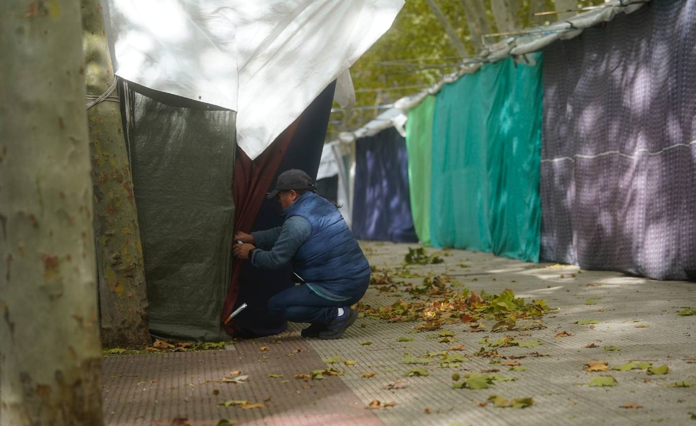 Un hombre amarra los toldos de uno de los puestos colocados en la plaza de la Constitución.