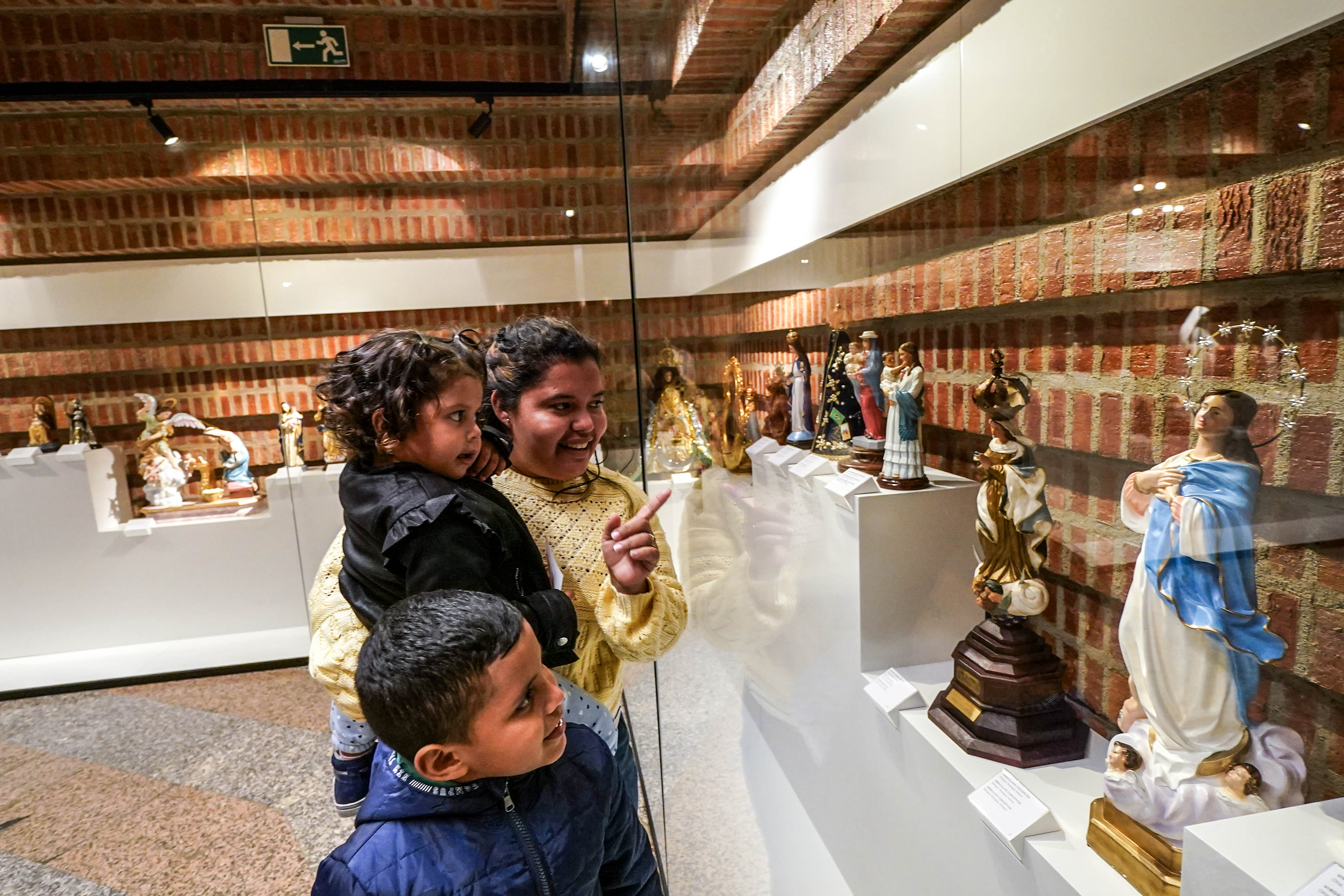 Walkiria Carrasco, nicaragüense, contempla con sus hijos una Virgen de su país.