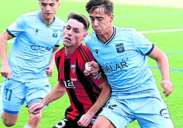 Mikel Zabala trata de hacerse con el balón ante un rival.