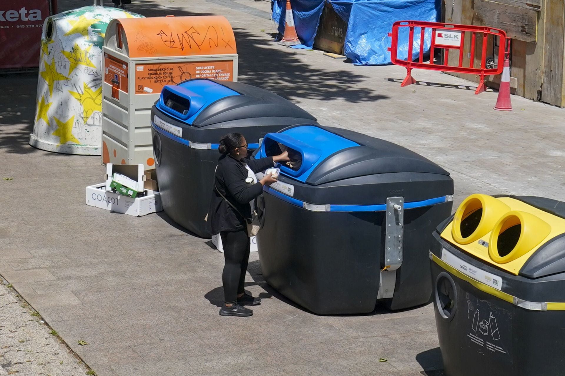 Una mujer hace uso de un contenedor de papel.