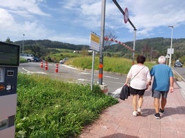 Una pareja camina junto a uno de los parkings disuasorios de Lekeitio.