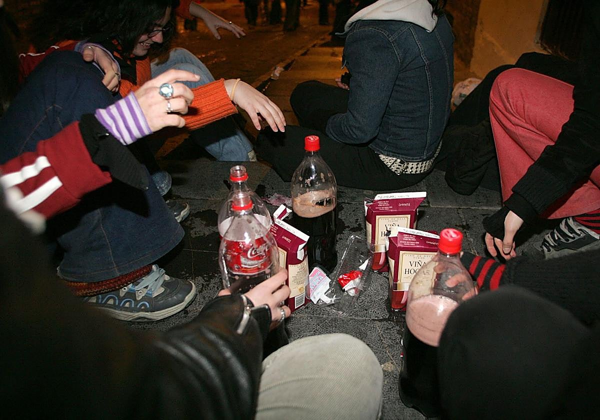 Varios jóvenes realizan un kalimotxo tradicional.