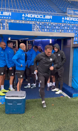 Luis García salta al césped bajo una intensa lluvia.