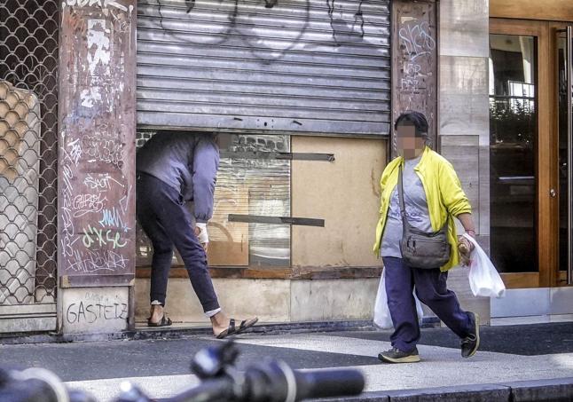 Un okupa sale de la lonja de Cruz Blanca número 3.