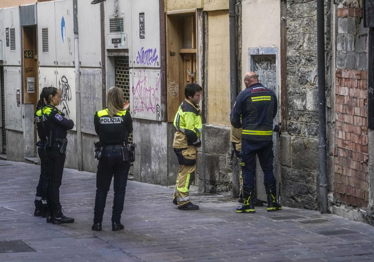 Agentes locales escoltan a los bomberos durante el cierre de una lonja okupada en la calle Santo Domingo. La escena corresponde al viernes.