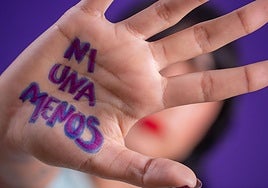 Imagen de una mujer con el mensaje 'Ni una menos' escrito en la palma de la mano.