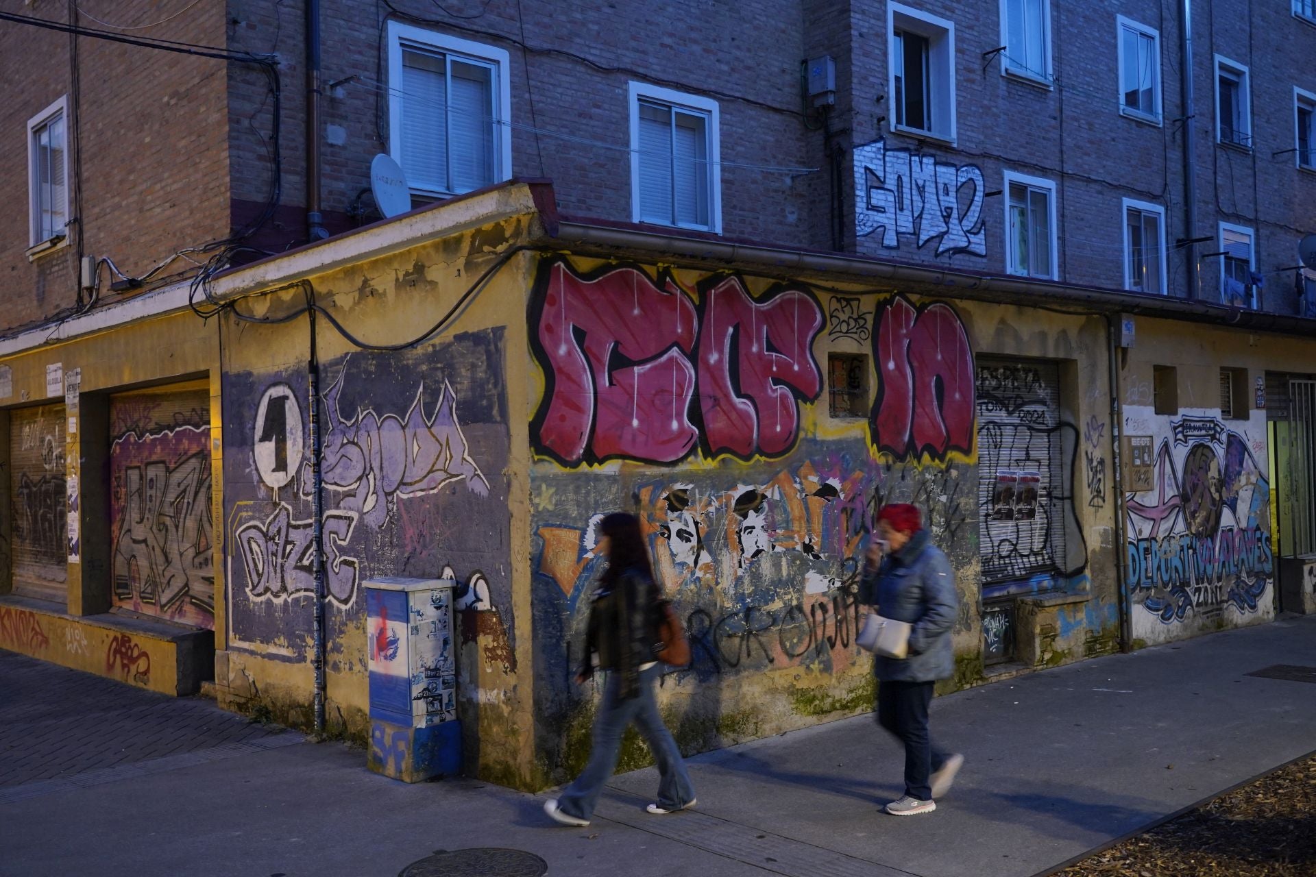 Grafitis emborronan una fachada de un edificio de Ariznabarra.