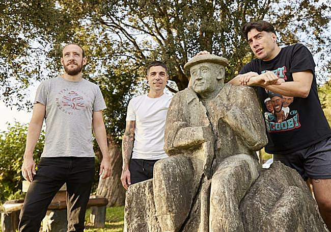 Jon Sola, Julen Baz y Eneko Axpe junto a la estatua de Julián Larrea, hendida por el rayo, que ha dado origen a su revolucionaria máquina de cocina, que asa carne en segundos