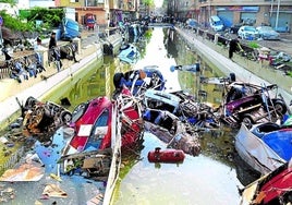 Espectáculo dantesco. Montañas de coches se acumulan en el cauce que cruza la localidad valenciana de Alfafar.