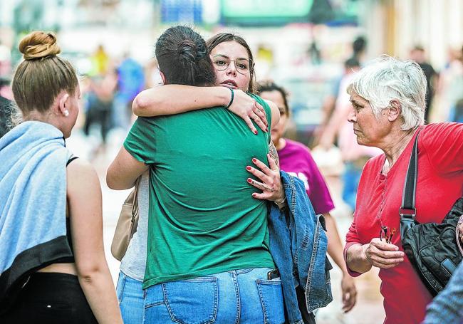 Vecinos y allegados se abrazan.