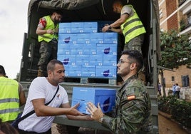 Vecinos de Paiporta reciben agua repartida por el Ejército.