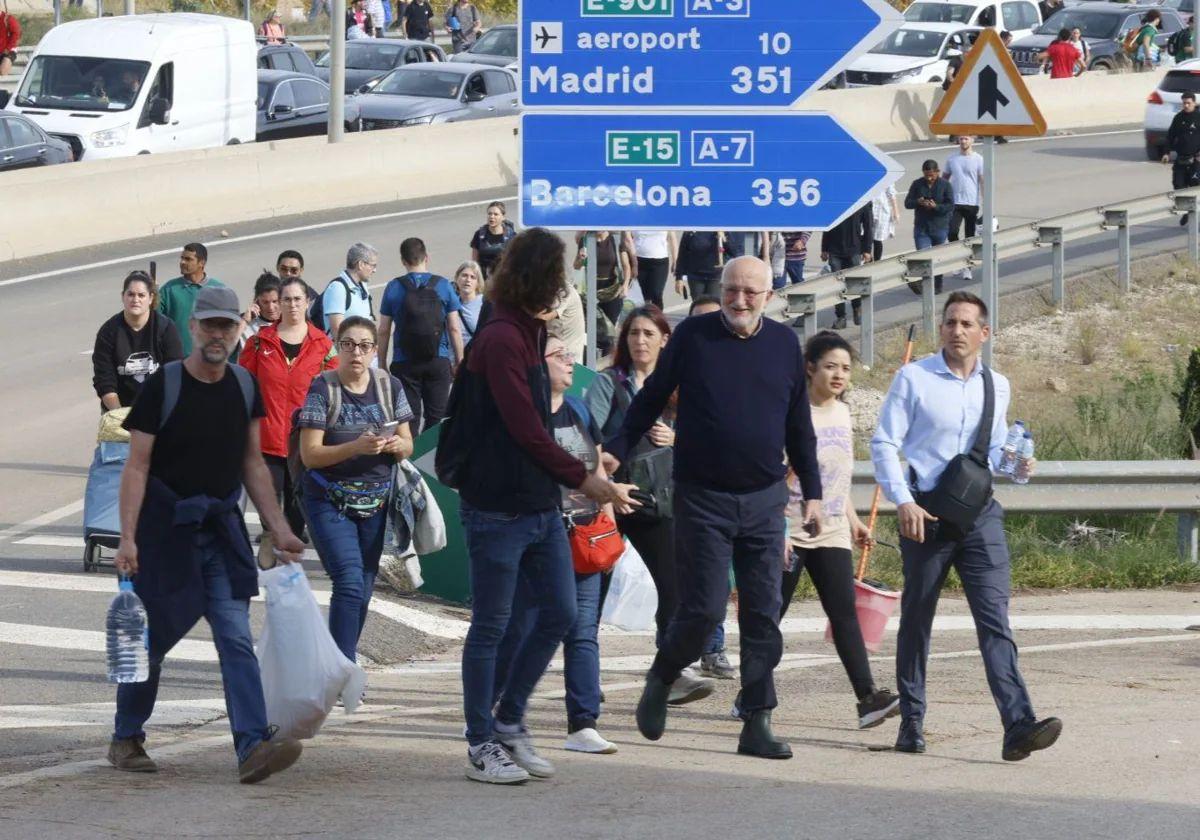 El empresario valenciano Juan Roig camina con rumbo a Benetússer entre los cientos de valencianos que avanzan con ayudas para las víctimas.