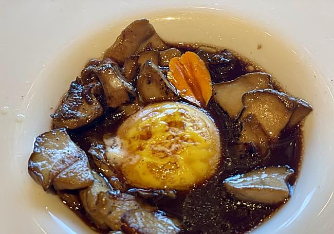 Sabroso plato de boletus con yema de huevo de caserío y consomé de rabo.