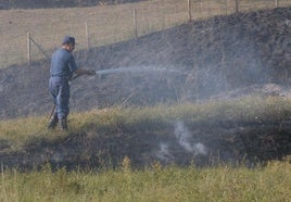 Un agricultor ajeno a los hechos refresca un terreno donde quema rastrojos.